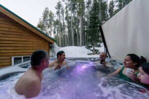 Friends enjoying a hot tub in the snow