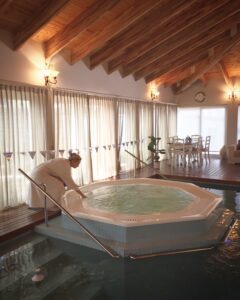 Mujer entrando a un jacuzzi en el spa