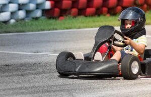 An eight-year-old boy operates a go-kart.