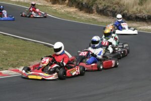 A line of go-karts speeding around a curve.