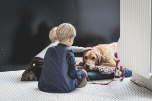 dos niños acariciando a un perro cansado