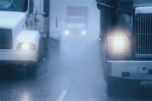 Conductores de camiones moviéndose a través de una niebla espesa