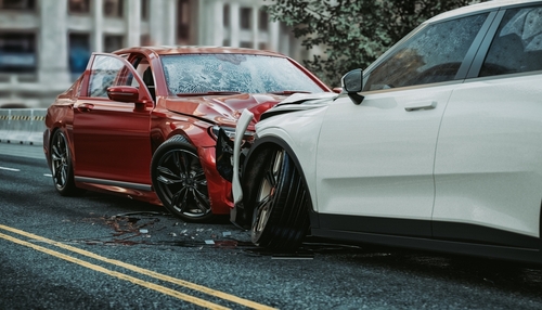 Two cars involved in a head-on collision on a road in Stafford, with significant front-end damage.