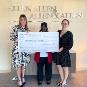The Giving Heart's Sandra Antoine (center) flanked by Allen & Allen's Erin Jenkins (left) and Maggie McBrady (right)
