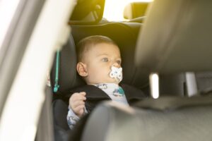 Bebé en el asiento del coche chupando un chupete