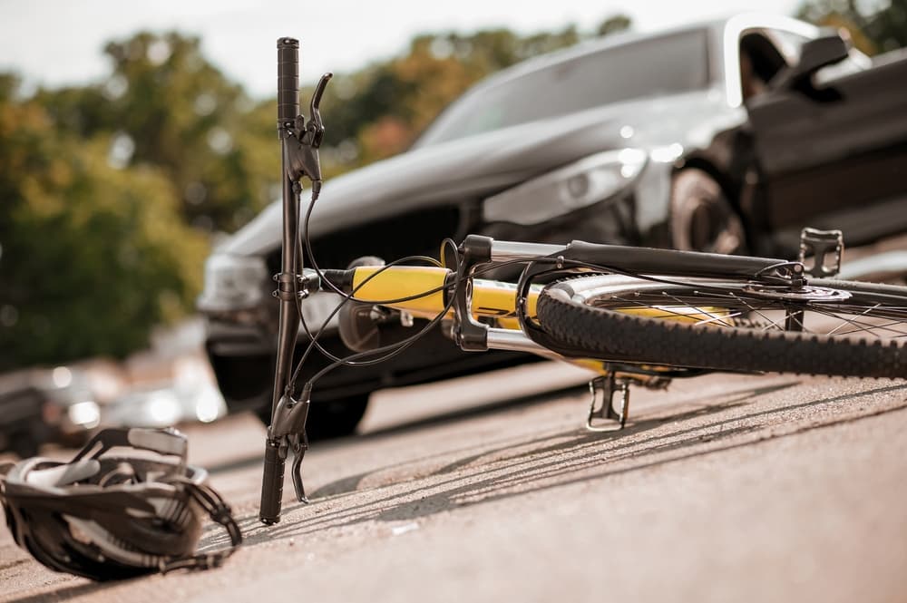 Bicycle and helmet lying on road and car Bicycle and helmet lying on road and car