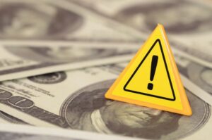 The cautionary triangle sign amidst a sea of dollar bills