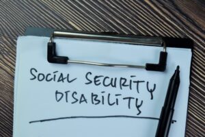 Social Security Disability write on paperwork isolated on Wooden Table.