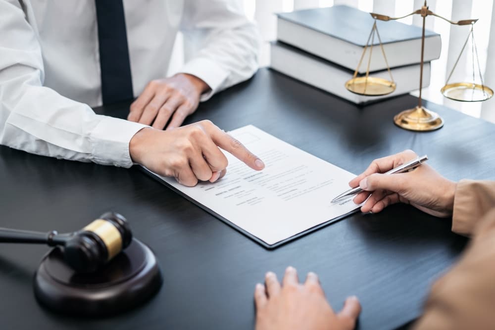 A Lawyer and is guiding to guild where to sign a document during free consultation A Lawyer and is guiding to guild where to sign a document during free consultation