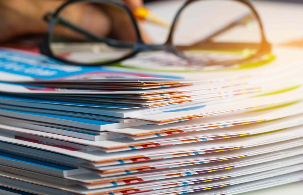 Stack of paperwork and documents on a desk with eyeglasses, representing legal case files, insurance claims, or accident documentation. Stack of paperwork and documents on a desk with eyeglasses, representing legal case files, insurance claims, or accident documentation.