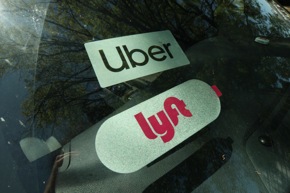 Primer plano de las etiquetas de Uber y Lyft en la ventana de un vehículo.